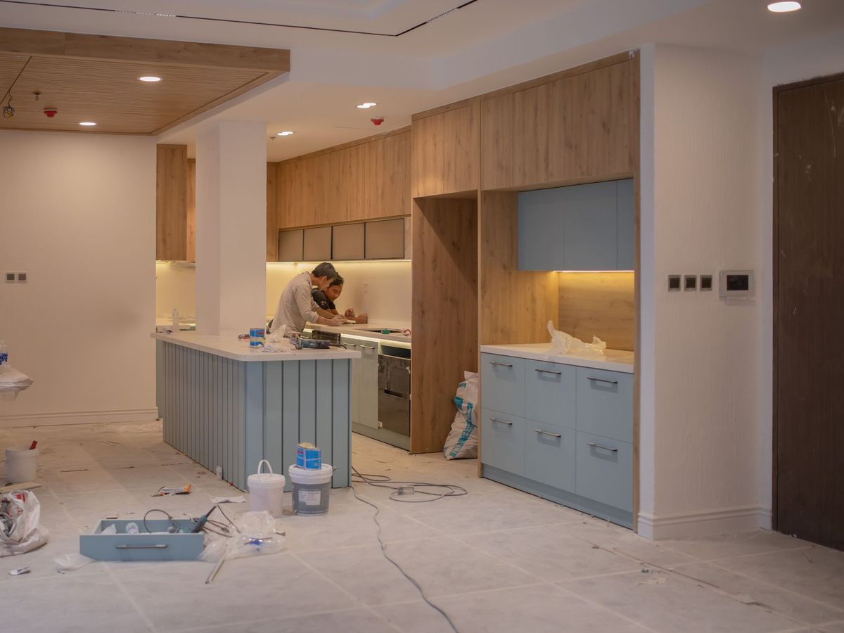 Twee vaklui werken een nieuwe keuken af in een ruimte in renovatie
